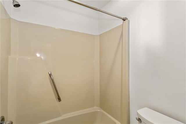 bathroom featuring washtub / shower combination and toilet