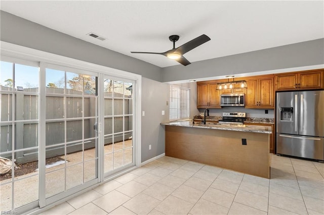 kitchen with light stone countertops, ceiling fan, stainless steel appliances, kitchen peninsula, and light tile patterned floors