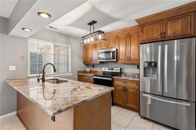 kitchen with sink, appliances with stainless steel finishes, decorative light fixtures, light tile patterned flooring, and light stone counters