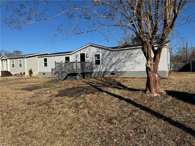 back of property with a wooden deck and a yard