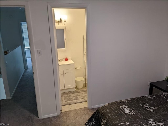 bedroom featuring ensuite bathroom, carpet, and sink