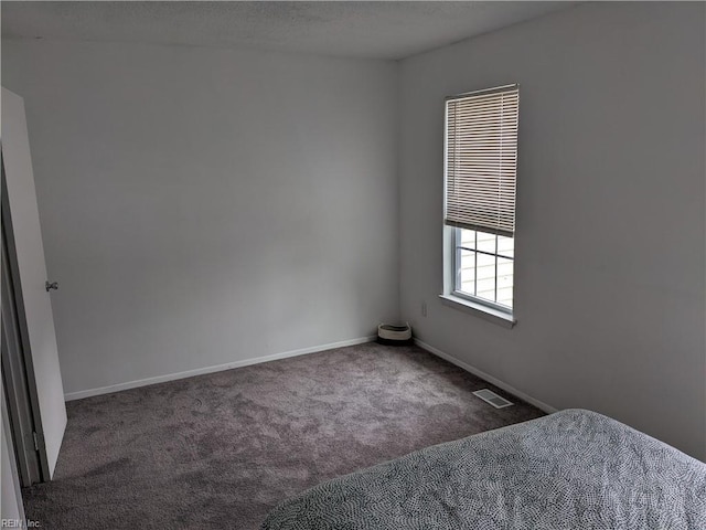 unfurnished bedroom with dark carpet