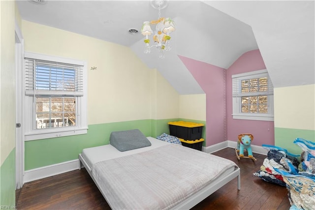 bedroom with an inviting chandelier, vaulted ceiling, and dark hardwood / wood-style floors