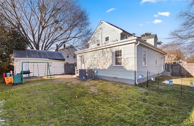 back of property with cooling unit, a shed, and a lawn