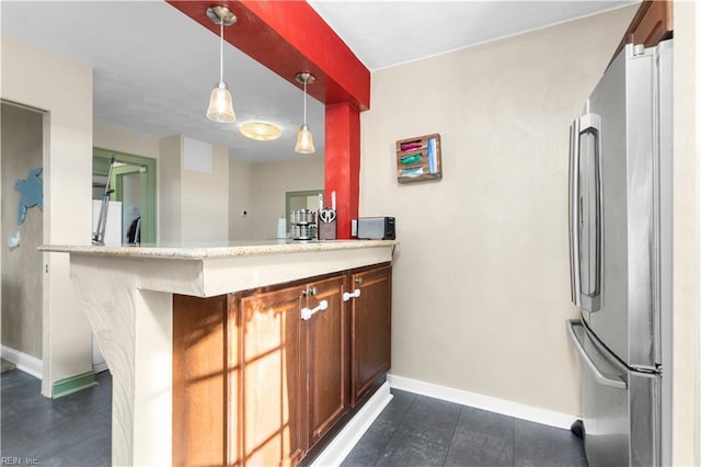 kitchen with decorative light fixtures, kitchen peninsula, and stainless steel fridge