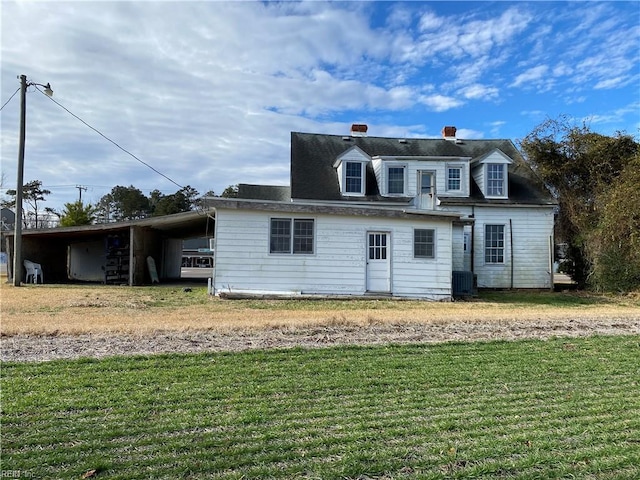 back of house featuring a carport, cooling unit, and a yard