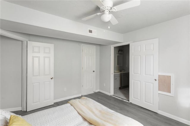 bedroom featuring ensuite bathroom, dark hardwood / wood-style flooring, ceiling fan, and sink