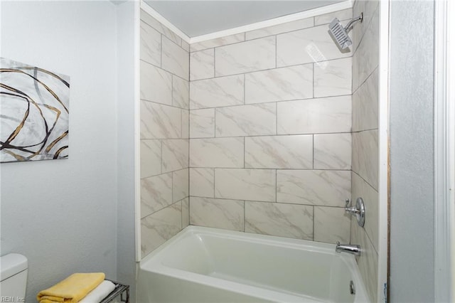 bathroom featuring toilet and tiled shower / bath