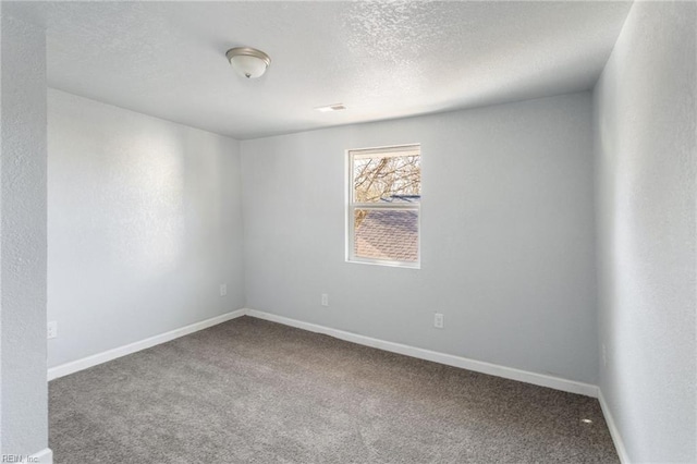 carpeted empty room featuring a textured ceiling