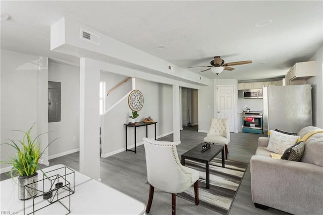 living room with electric panel, ceiling fan, and hardwood / wood-style floors