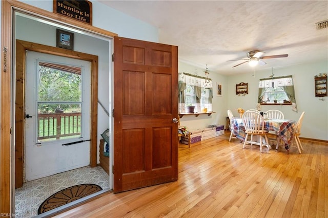 dining area with ceiling fan and light wood-type flooring