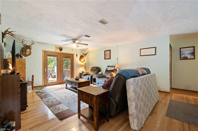 living room with ceiling fan, light hardwood / wood-style flooring, and french doors