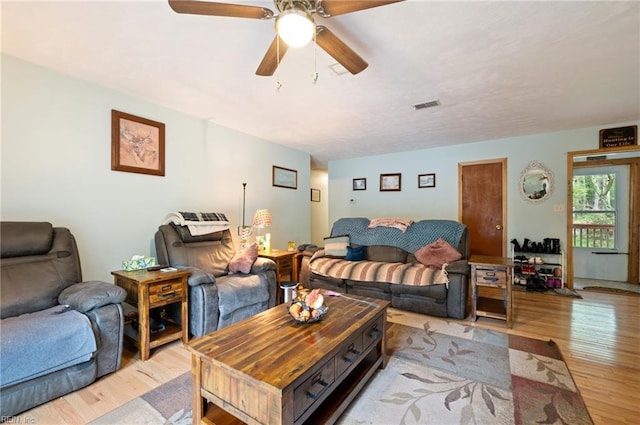 living room with ceiling fan and light hardwood / wood-style flooring