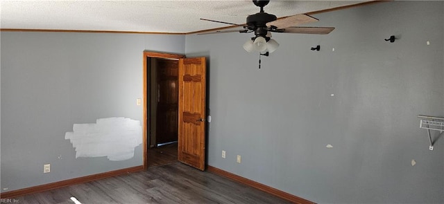 spare room with dark hardwood / wood-style floors, ceiling fan, and crown molding