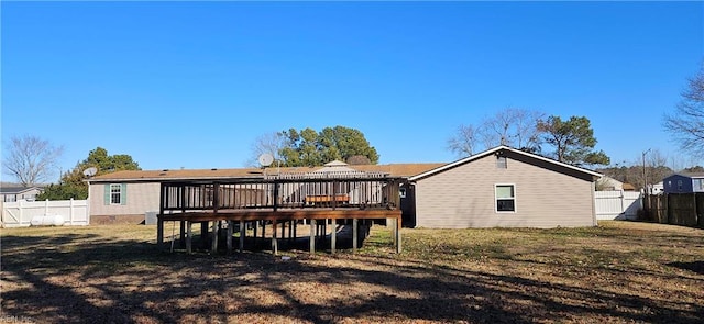 rear view of property featuring a yard and a wooden deck