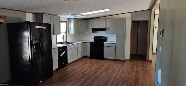 kitchen featuring sink, dark hardwood / wood-style flooring, backsplash, vaulted ceiling, and black appliances