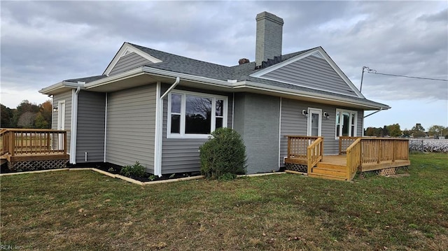 rear view of house with a deck and a lawn