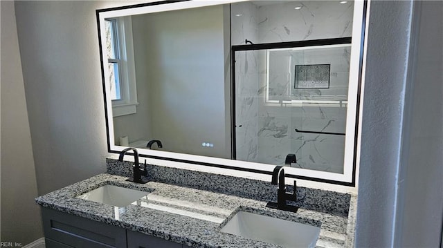 bathroom featuring a shower with door and vanity