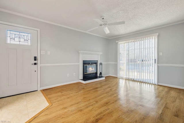 unfurnished living room featuring ceiling fan, crown molding, a textured ceiling, and wood-type flooring