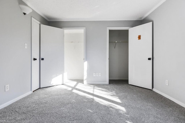 unfurnished bedroom with a textured ceiling, ornamental molding, and carpet flooring