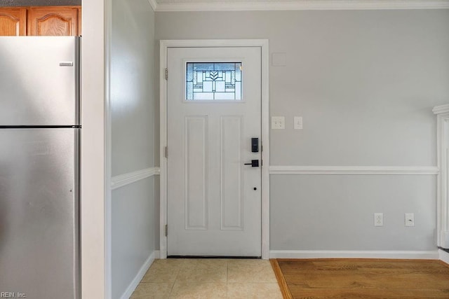 tiled foyer entrance featuring ornamental molding