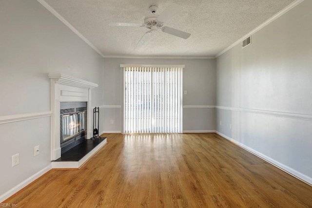 unfurnished living room with a textured ceiling, ceiling fan, hardwood / wood-style flooring, and crown molding