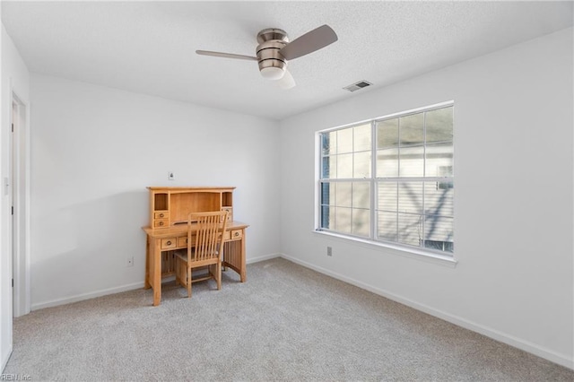 carpeted office space featuring ceiling fan