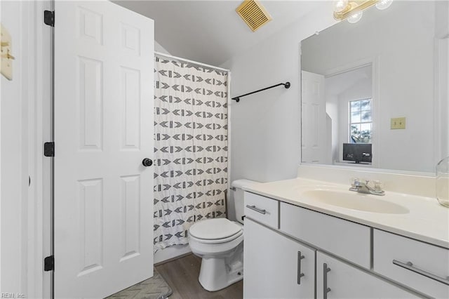 bathroom with wood-type flooring, toilet, and vanity