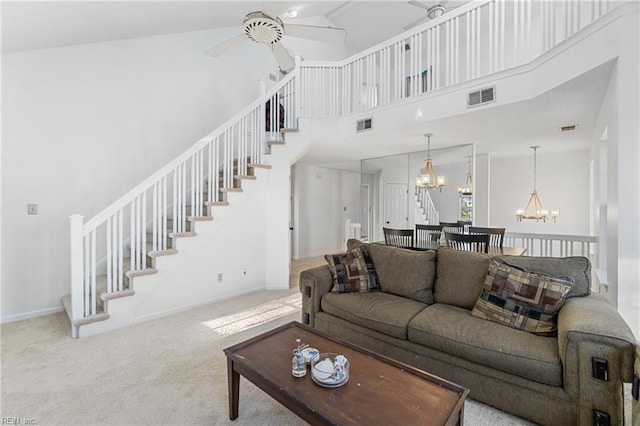 living room featuring carpet, ceiling fan with notable chandelier, and high vaulted ceiling