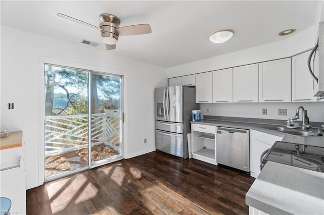 kitchen with ceiling fan, appliances with stainless steel finishes, dark hardwood / wood-style flooring, white cabinets, and sink