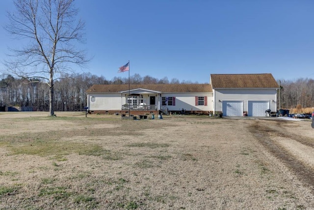 view of front of house featuring a front yard, a garage, and covered porch