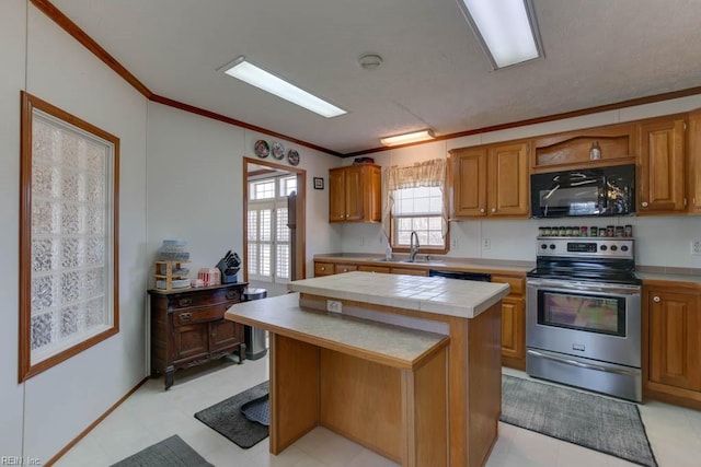 kitchen with a center island, crown molding, stainless steel electric range oven, tile countertops, and sink