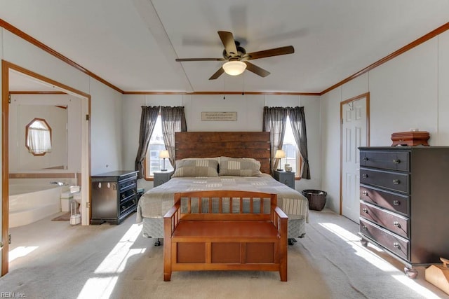 carpeted bedroom featuring ceiling fan, ornamental molding, and ensuite bath