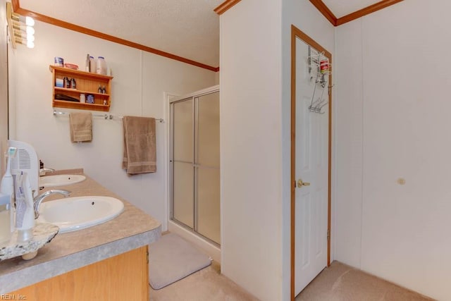 bathroom with vanity, crown molding, and a shower with shower door