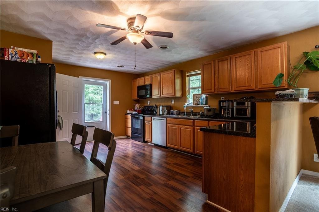 kitchen with ceiling fan, sink, black appliances, and dark hardwood / wood-style floors