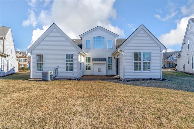 rear view of property with central AC and a lawn