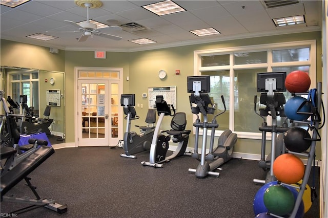 gym with ornamental molding, a drop ceiling, and ceiling fan