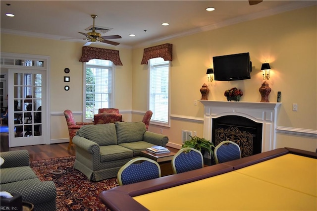 living room featuring ceiling fan, ornamental molding, and dark hardwood / wood-style flooring