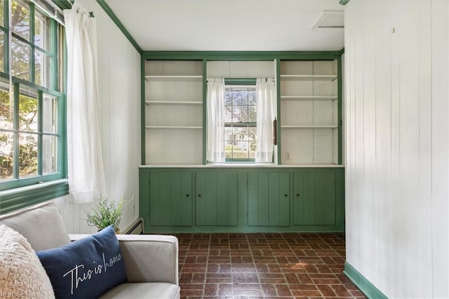 sitting room featuring baseboard heating and wood walls