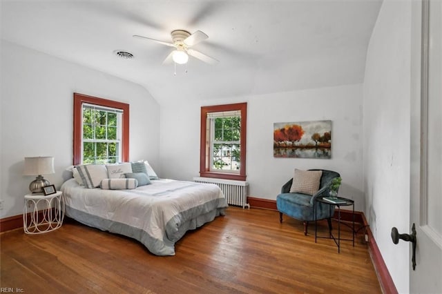 bedroom featuring lofted ceiling, hardwood / wood-style flooring, ceiling fan, and radiator heating unit