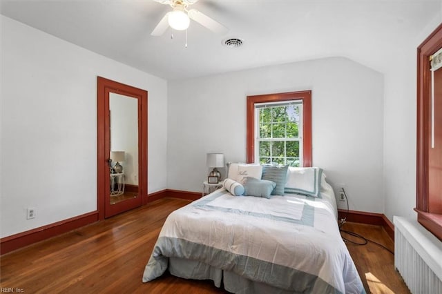 bedroom with ceiling fan, radiator, and wood-type flooring