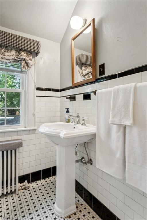 bathroom featuring radiator, tile patterned flooring, and tile walls