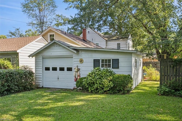 view of front of house with a front yard, a garage, and an outdoor structure