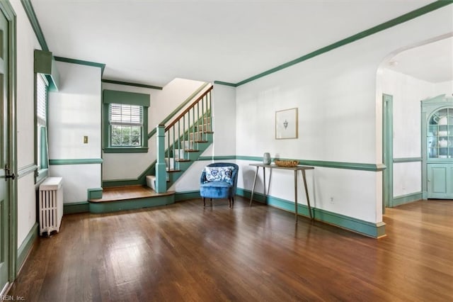 interior space featuring radiator, wood-type flooring, and ornamental molding