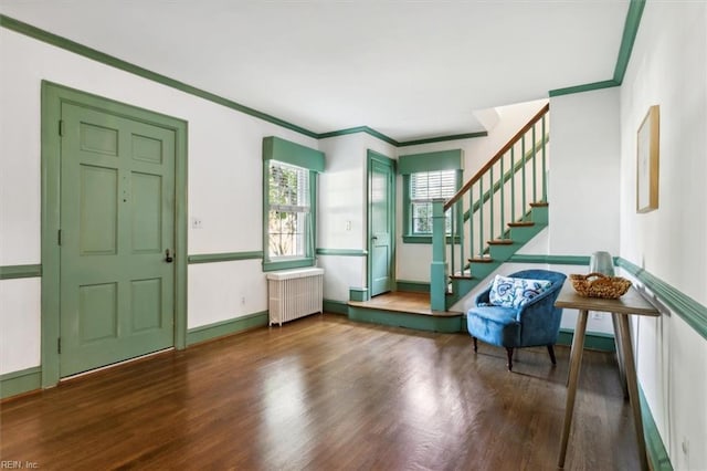 foyer entrance with ornamental molding, dark hardwood / wood-style flooring, and radiator heating unit