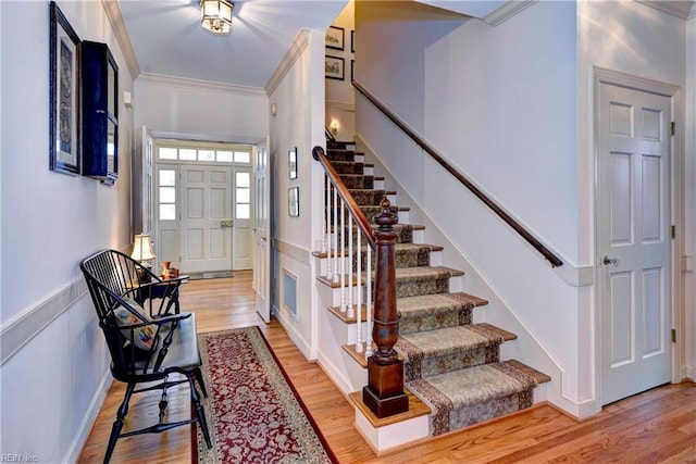 foyer featuring crown molding and hardwood / wood-style floors