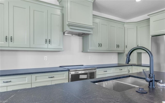 kitchen with sink, stainless steel appliances, and dark stone countertops