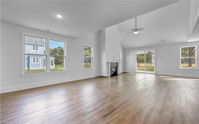 unfurnished living room featuring wood-type flooring, ceiling fan, and vaulted ceiling