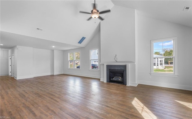 unfurnished living room with high vaulted ceiling, ceiling fan, a healthy amount of sunlight, and dark hardwood / wood-style floors