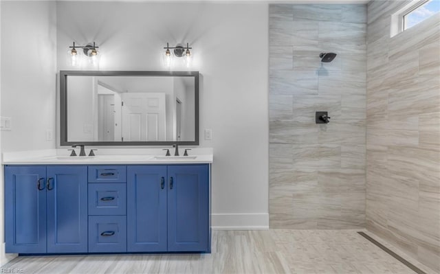 bathroom featuring a tile shower and vanity